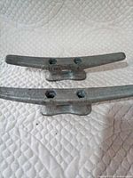 Top view of both 8-inch dock cleats showing mounting holes and stamped origin