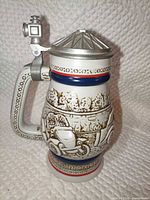 Full view of stein, lid closed, vintage car relief visible