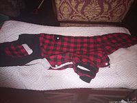 Full view of red/black buffalo check dog coat laid flat