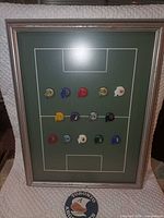Entire framed display showing pins on green field background