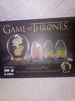 Front of boxed Game of Thrones collector puzzle set showing globe and dragon eggs