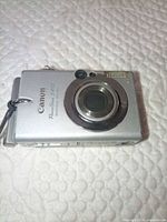 Canon PowerShot S410 front view showing lens, body condition, wrist strap