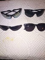 All four pairs of sunglasses displayed on surface