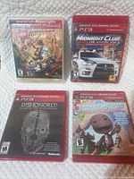 All four PS3 games with cases laid out