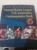 Front cover showing title, NHL 75th logo, player photos on dust jacket