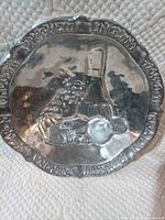 Full view of pewter plate showing wine bottle and grapes motif