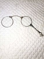 Full view of folding lorgnette with both circular lenses and handle