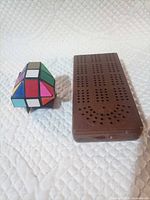 Twisty puzzle and cribbage board side by side