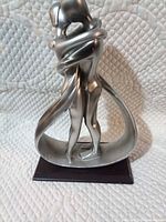 Front view of silver resin couple figurine on wood base