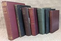 Seven antique books standing to show spines