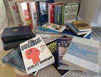 Group view of assorted books spread on bed showing covers and upright spines
