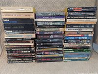 Overall view showing three stacks of pocket-size paperbacks (51 total)