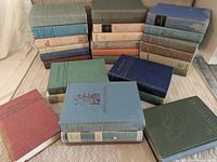 Group shot of all 27 cloth-bound guide books stacked on seat