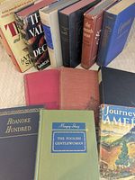 Lot overview showing 12 vintage hardcovers; front row displays Roanoke Hundred, The Foolish Gentlewoman and Journey into America; rear row shows remaining titles
