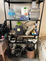 Full shelving unit showing assorted cookware, boxed items and small appliances