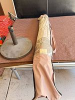 Umbrella in carry bag beside round base on table