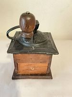 Front view showing wood body, cast top, drawer