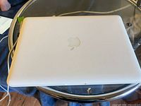 Closed white MacBook showing Apple logo on lid