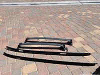 overview of four roof rack pieces laid on pavement