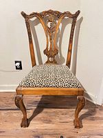 Full front view of chair displaying overall design, upholstery, legs, and finish