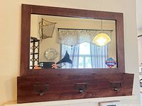 Front view of wall mirror showing storage box with hooks and label holders