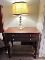 Front view of Ethan Allen nightstand showing two drawers, cane shelf, turned legs