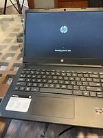 Open HP laptop showing screen resetting, keyboard, AMD sticker