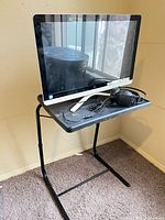 HP all-in-one desktop on folding table with headphones placed on top