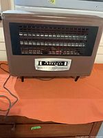 Front view of Knapp-Monarch brown electric heater showing grille, control panel and power cord