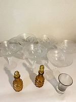Group view of six coupes, two amber cruets with stoppers and one shot glass