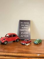 Sign with text and three model cars on tabletop