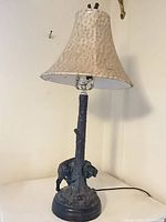 Front view of rustic cast metal elephant table lamp with fabric shade