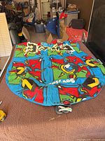 Deflated Sevylor tube laid flat showing full multicolor design, handles, and tow rope clip