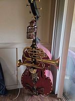 Full view of steampunk double bass sculpture showing attached brass horns and clock parts