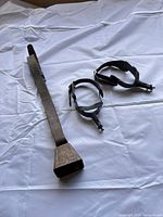 Full view of both spurs and leather strap with bell laid out