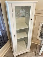 Front view of closed white curio cabinet