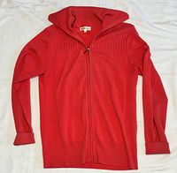 Front view of peach cotton full-zip sweater laid flat