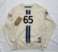 Full view of front of cream Red X Thread sweatshirt showing stripes, number 65, elbow patches, hang-tag
