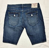 Rear view of denim shorts showing pockets, stitching and brand patch