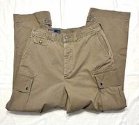 Front view of khaki cargo pants showing front pockets, cargo pockets, waistband label, and missing bottom button area