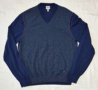 Front view of entire sweater laid flat showing color, V-neck, sleeves, waistband