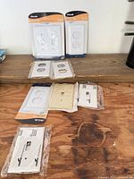 Group of packaged and loose wall plates on workbench