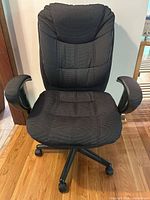 Front view of black mesh office chair showing seat, backrest, armrests, and base