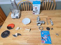 Overall view of food processor, grinder components, accessories and box on table