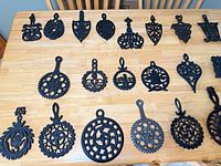 Overall view of assorted cast iron trivets laid out on tabletop