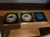 Three coins in cases on shelf