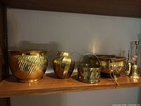 Shelf view showing planter, round vessel, basket, footed bowl and candlesticks