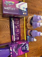 Boxed WetJet mop kit, box of 24 pads, sealed pad pack, three large cleaner bottles, one small cleaner bottle