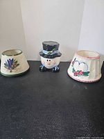 Front view of two candle topper shades and snowman jar assembled