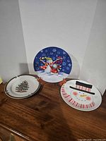 All three ceramic Christmas plates on display stand